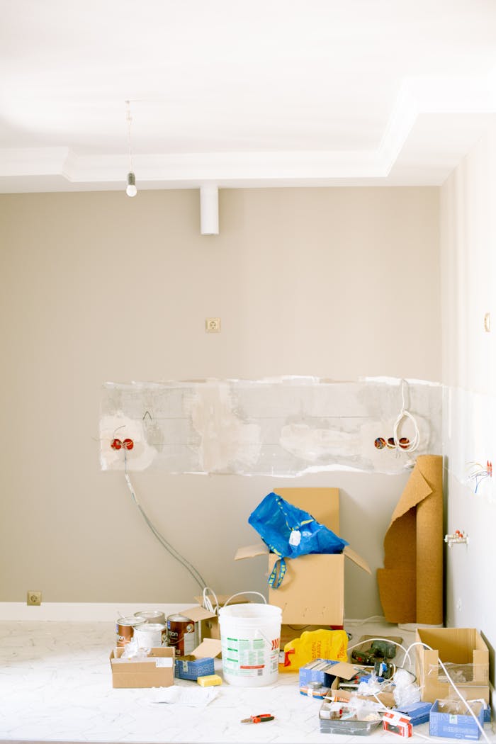 services-01 An indoor scene showing a messy home renovation project with tools, paint, and materials scattered around.