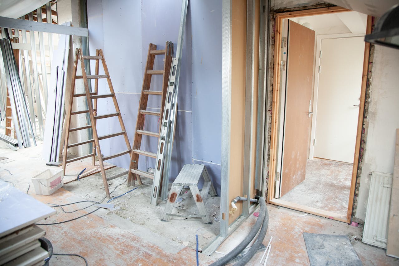 why-choose-us-02 Construction site featuring ladders and tools in a home renovation setting.